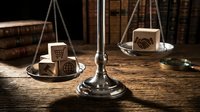 Wooden blocks with legal symbols on vintage brass scales in law office with books background representing justice and legal balance concepts.