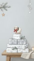 Stacked holiday gift boxes with sheep figurine, evergreen branches, hanging stars and snowflakes on wooden table for festive seasonal decoration and greeting card design.