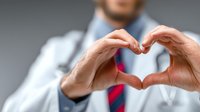 Healthcare professional making heart shape with hands showing compassion and care in medical practice for patient wellness and cardiology concepts.