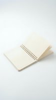 Open spiral-bound notebook with blank dotted pages on white background, isolated for design projects and office stationery mockups.