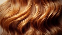 Luxurious wavy golden brown hair with honey blonde highlights flowing in soft curls, showcasing natural shine and healthy texture for beauty and haircare advertising.