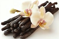 Aromatic vanilla pods with delicate orchid flowers on white background. Natural spice ingredient for baking, cooking and flavoring desserts.