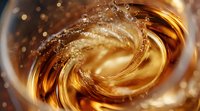 Swirling golden liquid creates dynamic splash with bubbles and droplets in glass, macro photography capturing amber fluid motion and light reflections in drink.