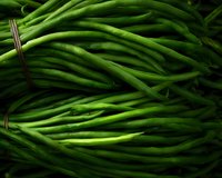 Fresh green string beans in dark moody lighting create dramatic food composition. Raw organic vegetables for healthy cooking and farm market design.