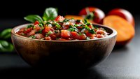 Homemade salsa with fresh tomatoes, cilantro, and onions in wooden bowl on dark surface, ready for cooking and food styling projects.