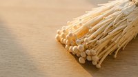 Dried corn cob with kernels removed on wooden surface, suitable for agricultural, craft, and educational content.