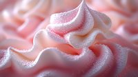 Soft pink whipped cream swirl with delicate texture and sparkling sugar crystals for dessert and bakery designs.