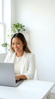 Happy Asian businesswoman working on laptop in modern bright office with plants creating productive workspace atmosphere for remote work success.