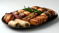 Grilled salmon sushi rolls and nigiri assortment on black oval plate with fresh garnish and sesame seeds, showcasing variety of Japanese cuisine preparations.