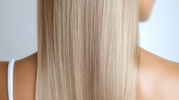 Smooth straight blonde hair with natural highlights showing healthy shine and texture from behind on white background.