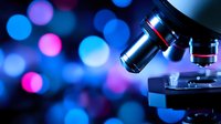 Professional microscope on dark background with blue and pink bokeh lights, scientific research equipment in laboratory setting for medical studies and analysis.