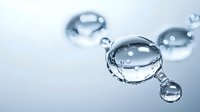 Macro photography of pure water drops with crown splash effect and air bubbles creating artistic composition on light blue background.