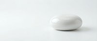 Single white oval pill capsule medication on clean white background with copy space for pharmaceutical and healthcare design projects.