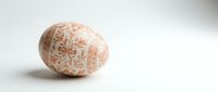Decorative Easter egg with intricate orange floral patterns on white background, traditional holiday ornament for spring celebrations and festive decor.