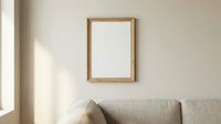 Minimalist living room interior with blank wooden frame mockup on beige wall, natural light, and neutral linen sofa in the foreground.