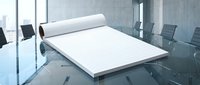Modern office conference room with blank white paper roll on glass table for business presentations and meetings.