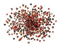 Mixed peppercorns and red chili flakes scattered on white background, isolated spice blend for culinary design and food packaging projects.