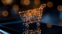 Glowing shopping cart made of connected light dots against dark background with bokeh effect, symbolizing digital commerce and online retail technology.