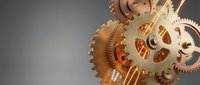 Golden mechanical gears and cogs in motion on gradient background showcasing precision engineering and clockwork mechanism for industrial design concepts.