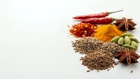 Aromatic spices and herbs collection with red chili peppers, turmeric powder, cumin seeds, star anise and cardamom pods on white background for cooking.