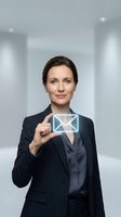 Professional woman in dark business suit holding envelope icon in modern office corridor, representing email communication, business correspondence, and digital messaging for corporate environments.