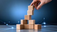 Hand stacking wooden blocks on glowing network background with connected dots, representing business growth, strategy and hierarchical structure.