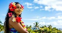 Young woman with long dark hair and South Asian ethnicity wearing colorful flower garlands and lei, smiling outdoors in tropical setting with palm trees and blue sky, suitable for travel and summer campaigns.