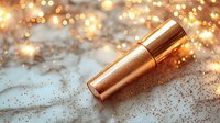 Luxurious rose gold lipstick with glitter sparkles on light surface against blurred bokeh lights background, glamorous cosmetic product photography.