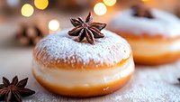 Sweet donut filled with vanilla cream, topped with powdered sugar and star anise on rustic wooden surface with festive bokeh lights in background.
