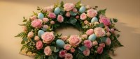 Elegant Easter wreath with pink roses, turquoise eggs, and lush greenery on a beige background, perfect for spring holiday decor.