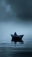 Paper boat floating on calm water surface against moody dark sky background, creating minimalist scene with reflection. Artistic composition for concepts of solitude.