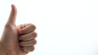 Hand showing thumbs up gesture on white background expressing approval and positive feedback for business presentations.