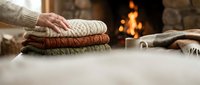 Senior woman organizing cozy knit sweaters by fireplace, autumn home comfort and hygge lifestyle for seasonal living spaces.