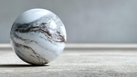 Marble sphere with natural veining patterns sits on textured surface against neutral background for modern decor and design projects.