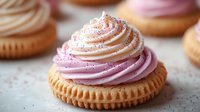 Delicious cupcakes with swirled pink and cream frosting on golden bases, sprinkled with colorful sugar pearls for bakery and dessert concepts.