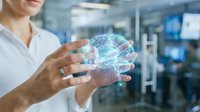 Female healthcare professional holding holographic brain model in modern medical facility for neuroscience research and digital health technology applications.