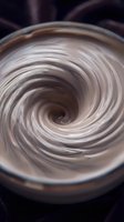 Creamy swirl texture in metallic bowl with spiral motion effect, suitable for cosmetics, skincare, food, and abstract design backgrounds.
