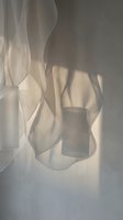 Ethereal white fabric flowing gracefully with soft shadows creating abstract sculptural forms against neutral background for luxury interior design.