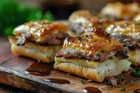 Juicy pulled pork sliders with caramelized onions and barbecue sauce on fresh buns, served on wooden cutting board with dripping sauce and garnish.