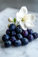 Fresh ripe blueberries with white jasmine flower on marble background. Macro food photography with soft natural lighting and shallow depth of field.