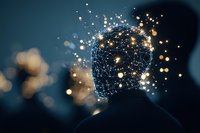 Glowing network of lights forming human head silhouette against dark background with sparkling bokeh effects, representing artificial intelligence and mind power.