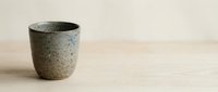 Rustic stone cup on wooden surface, minimalist design for home decor, lifestyle, and product photography projects.