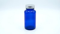 Blue glass pharmaceutical bottle with silver cap isolated on white background for medical packaging and supplement design applications.