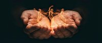 Cupped hands holding glowing flame symbolizing hope, protection, warmth and spiritual energy against dark background for inspirational concepts.