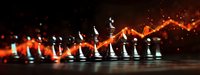 Chess pieces on dark background with glowing orange light trail effect and sparkles creating dramatic atmosphere for strategy and competition concepts.