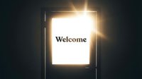 Glowing door opening to bright light with Welcome text, symbolizing new opportunities, hope, and positive beginnings in dark surroundings.