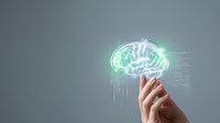 Digital brain hologram with glowing neural networks floating above human hand against gray background for AI technology and innovation concepts.