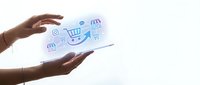 Hands holding tablet displaying shopping cart, store fronts, and commerce icons for retail, e-commerce, and digital business concepts.