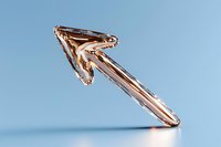 Metallic rose gold arrow pointing upward against light blue background, modern minimalist design element for business and financial growth concepts.