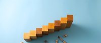 Wooden blocks stacked in ascending staircase pattern on light blue background, symbolizing growth, progress, and business success for corporate presentations.